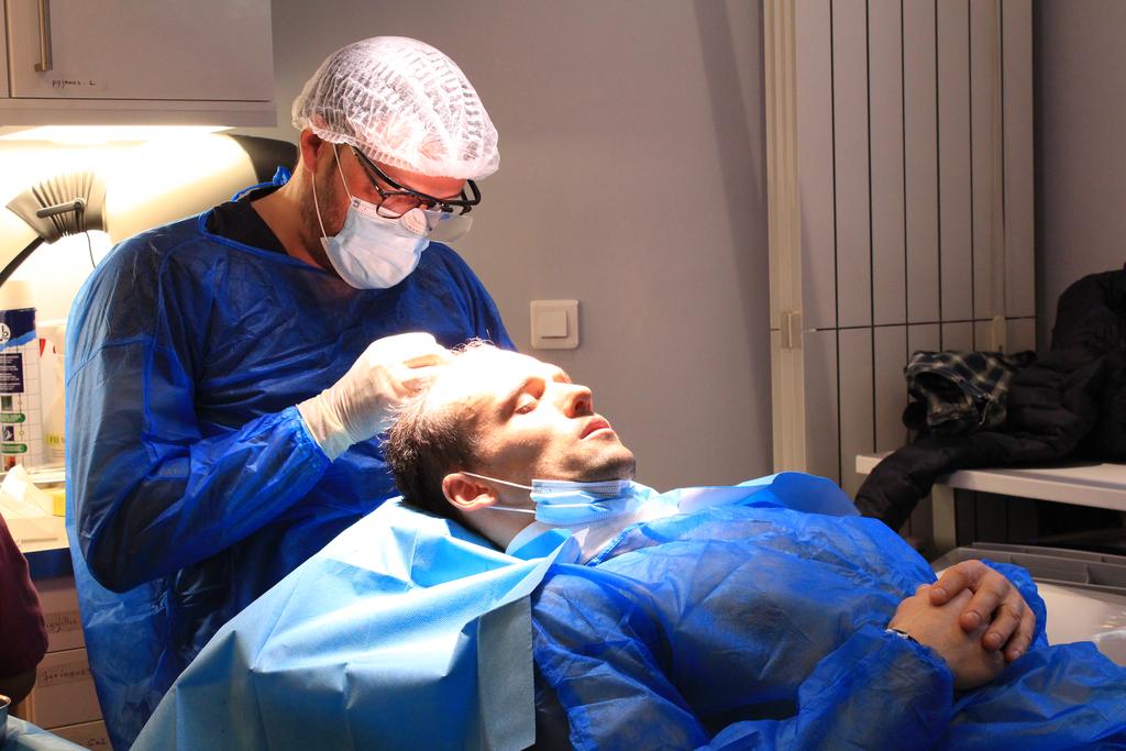 Patient recevant une anesthésie locale avant une greffe de cheveux FUE dans un cabinet médical à Paris
